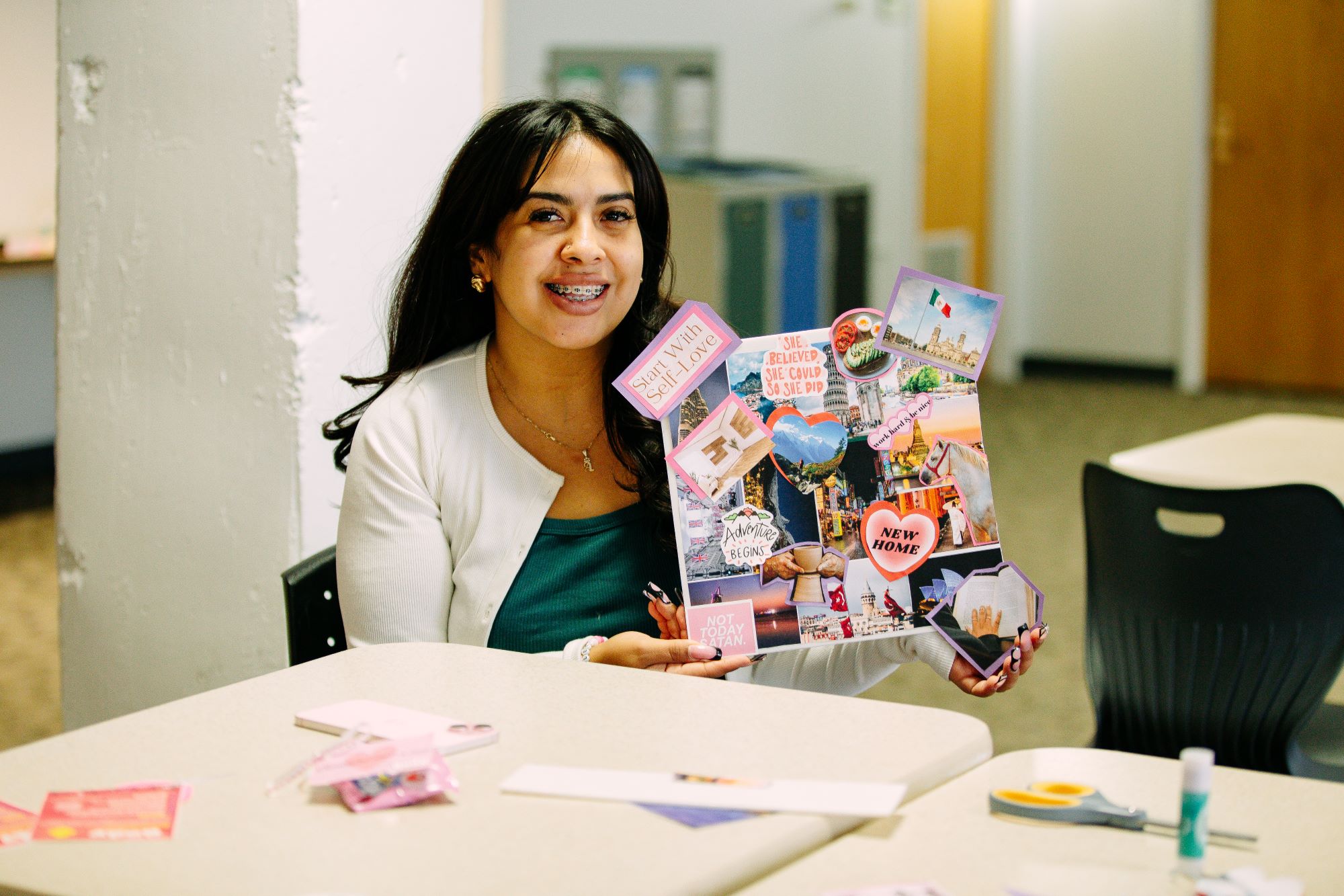girl holding up a vision board