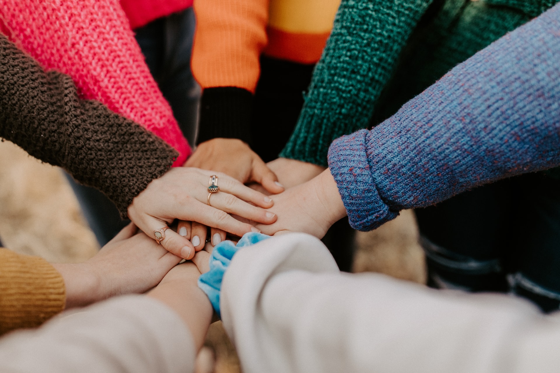 A close-up of multiple people's hands stacking on top of each another.