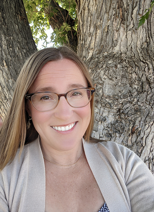 Crystal Gasell smiling in front of a tree.