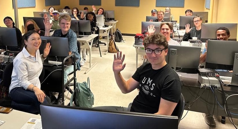 Photo of Dr. Wu's Music Students Sitting at Computers and Waving to Camera