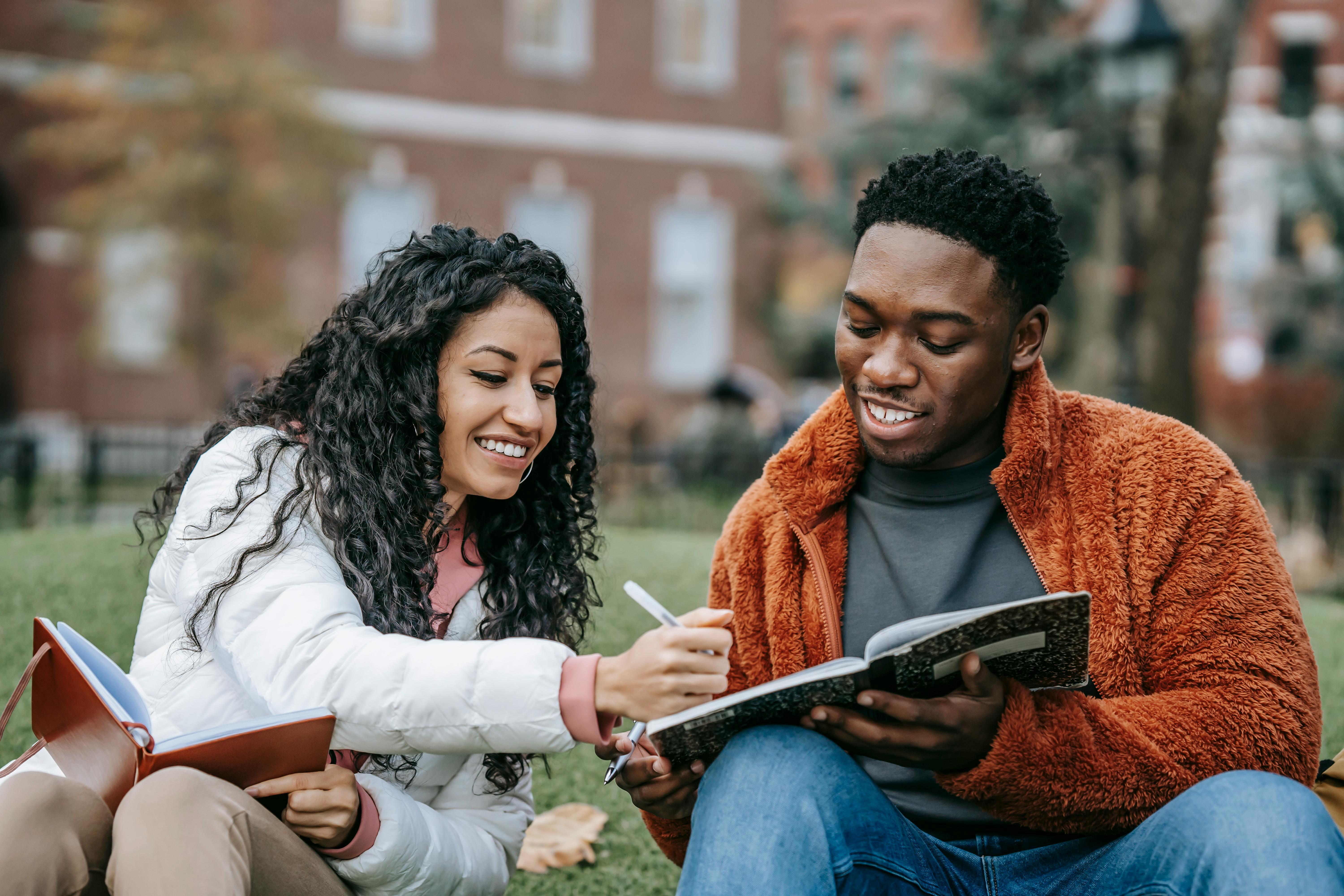 Two people talking and pointing at a laptop