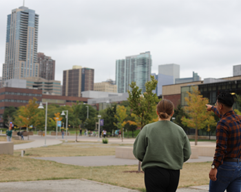 Juan and Morgan looking at the downtown denver skyline and pointing