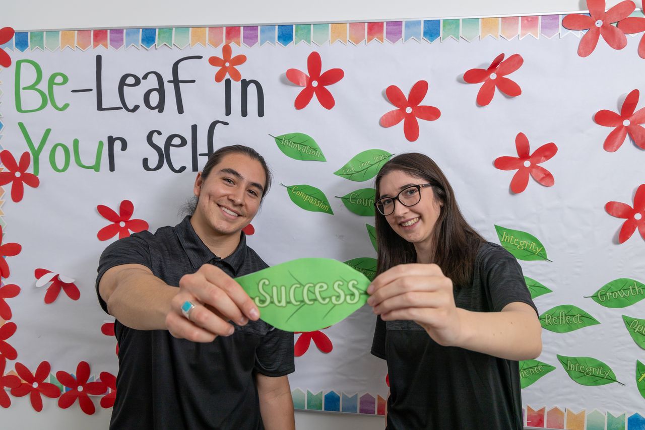 Two Resident Assistants Proudly Showing their Bulletin Board