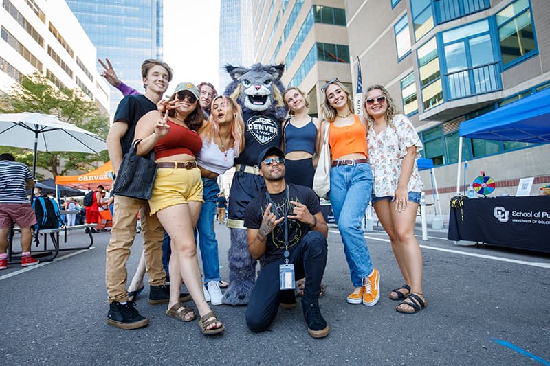 Large group of students posing with Milo the Lynx mascot at CU Denver Block Party.