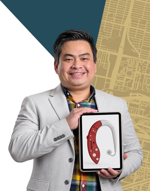 Man in a gray suite smiling and holding an award.