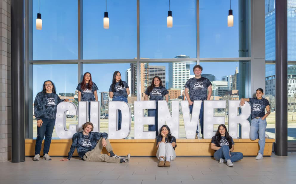 Group of students posed around big marque letters spelling CU Denver.