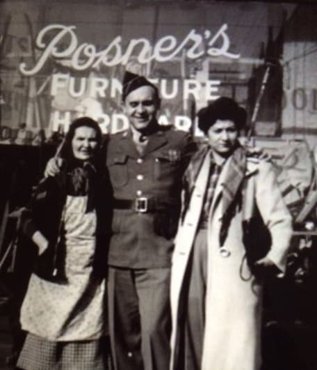 Jerry in his WWII uniform with his mother and sister on either side of him in front of the Posner store, black and white. 