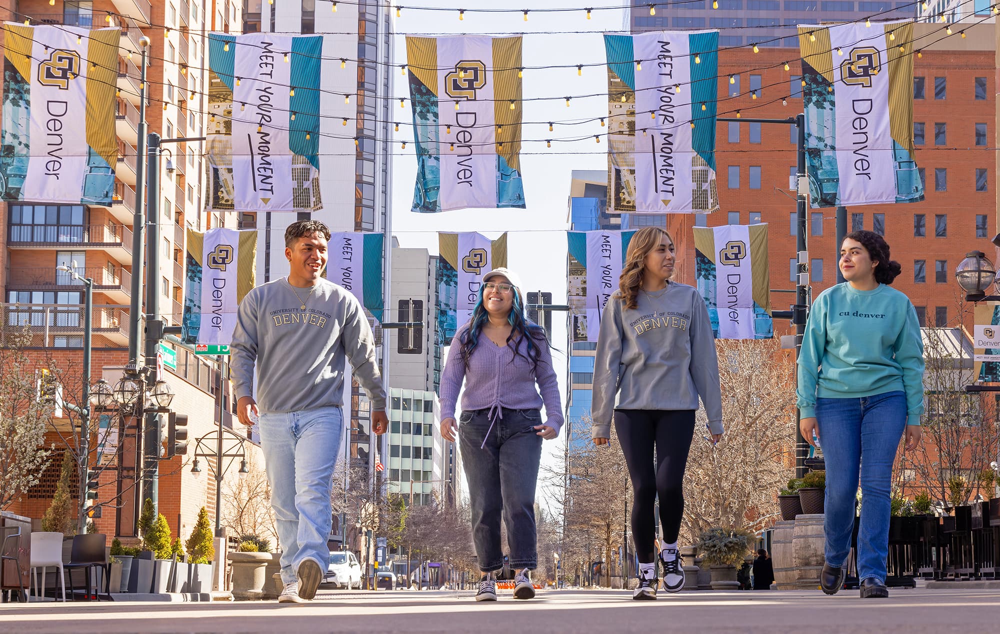Four CU Denver students walk together in Larimer Square