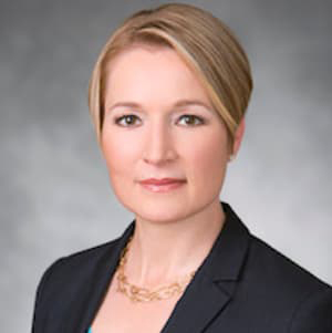Ellen Zentner with short, blonde hair and a dark blazer.
