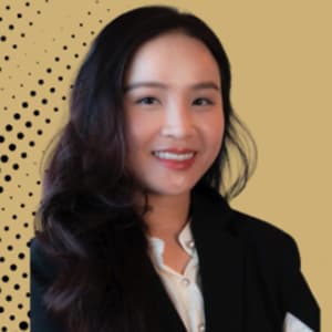 Woman with long black hair and a black blazer smiles with her teeth.