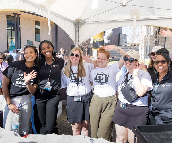 CU Denver admissions team posting for camera under a tent at on-campus event