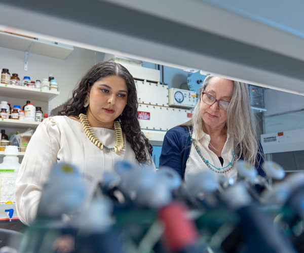 Student working with professor in science lab