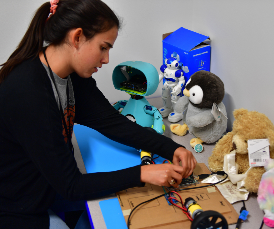Student focused on the electronics of adaptive toys