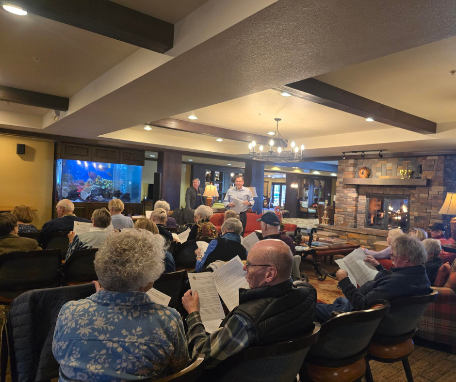 A group of older adults review pages during a meeting