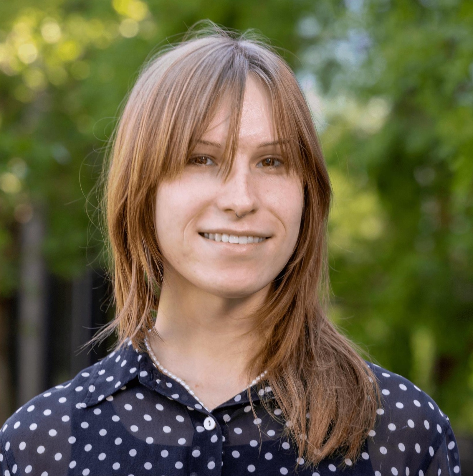 Marianne smiling outdoors in business casual attire