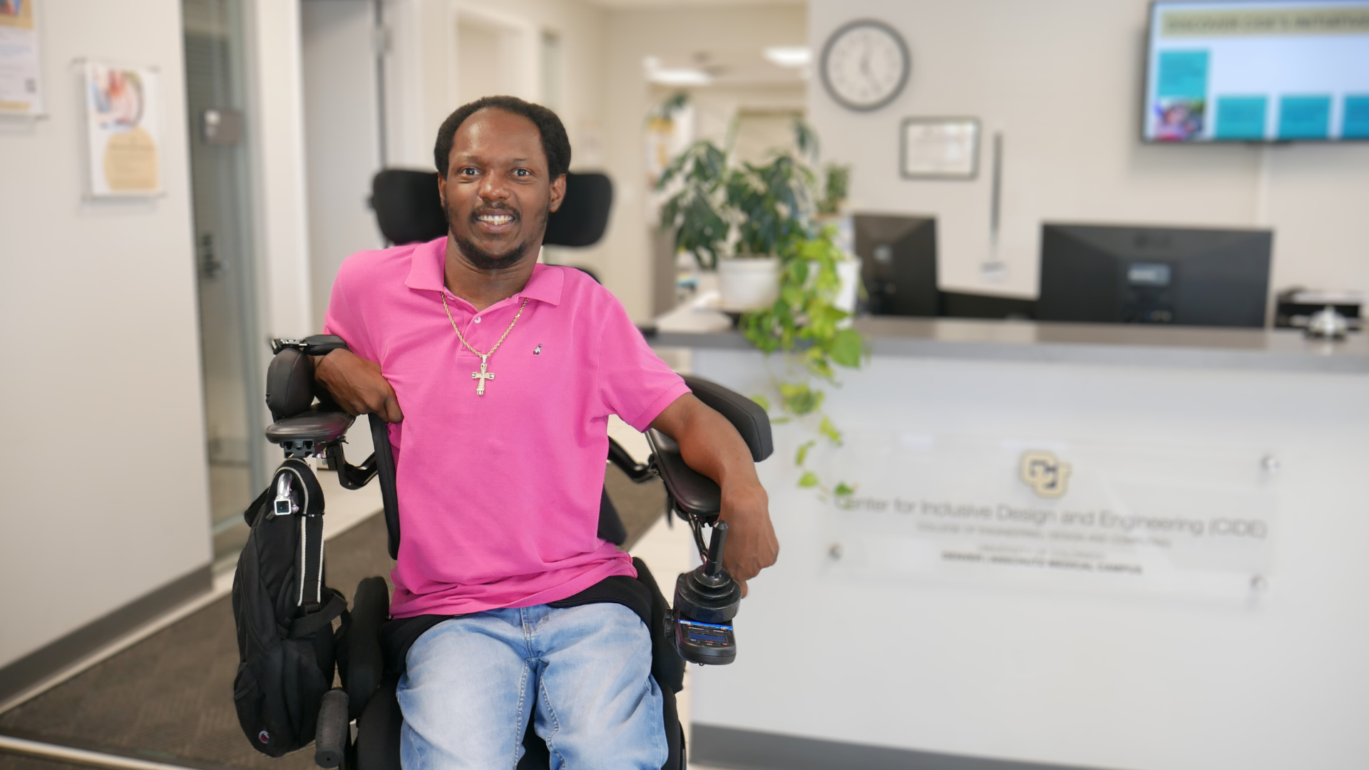 A man in a standing wheelchair smiles in the CIDE lobby