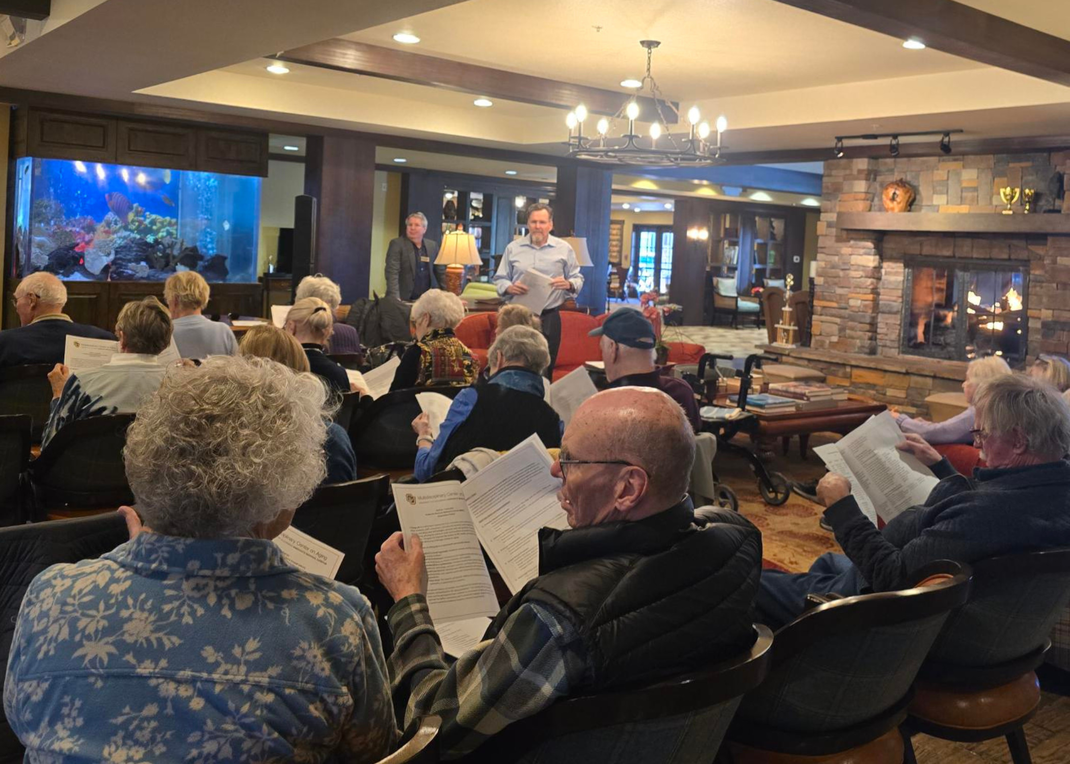 A group of older adults gathered in rows and reviewing paperwork
