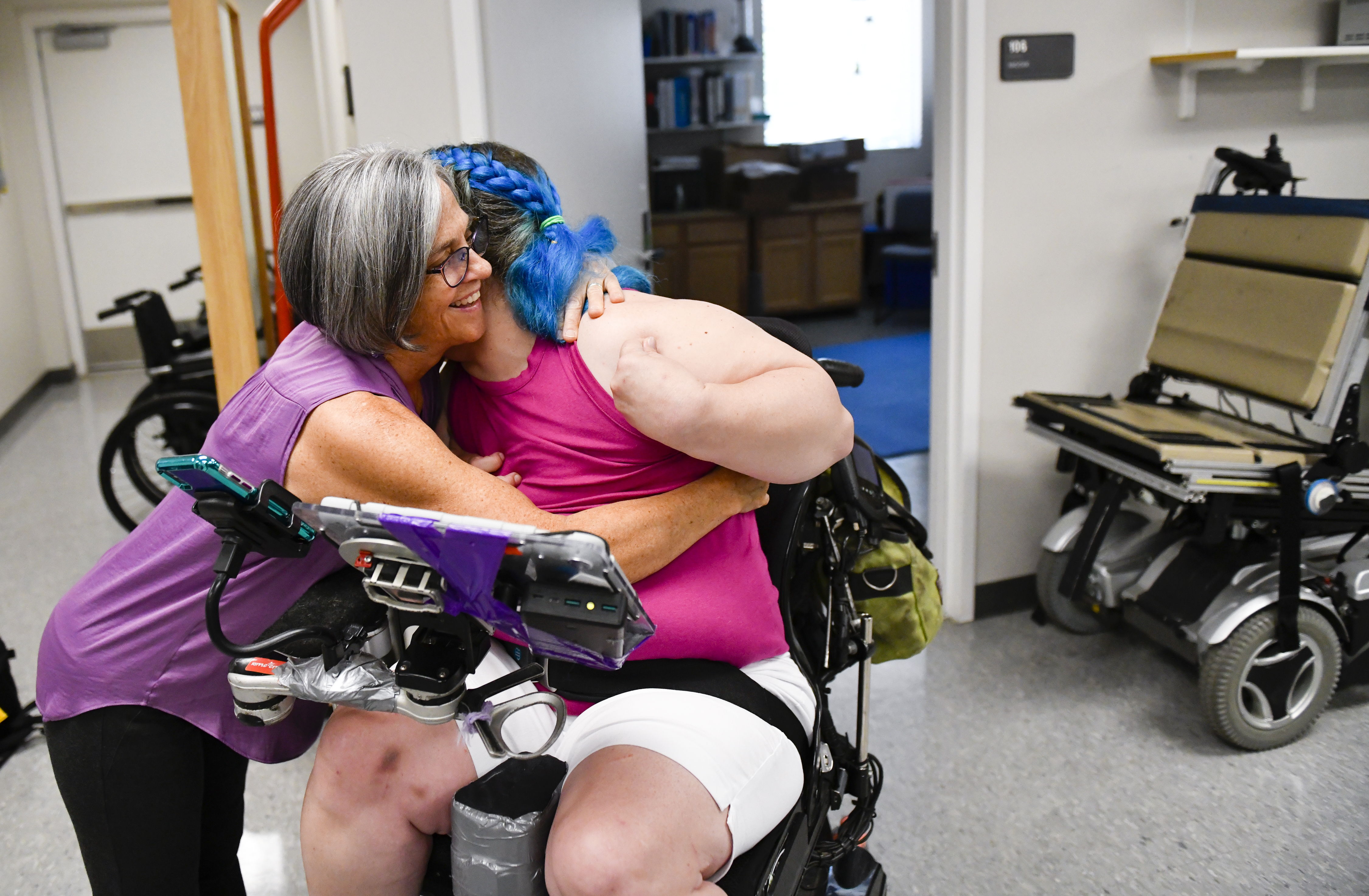 Kelly hugs client in wheelchair