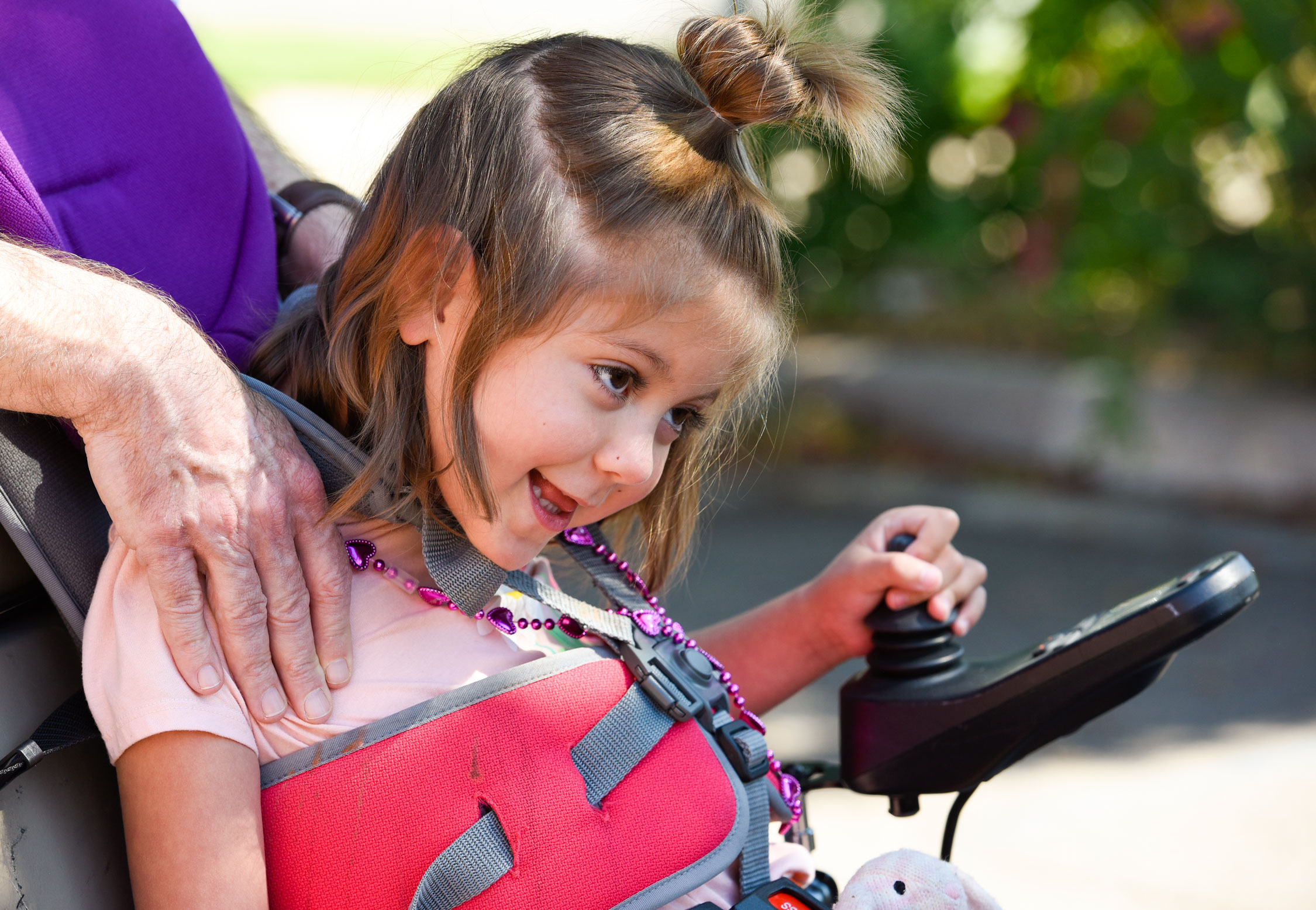 A young girl drives her power wheelchair